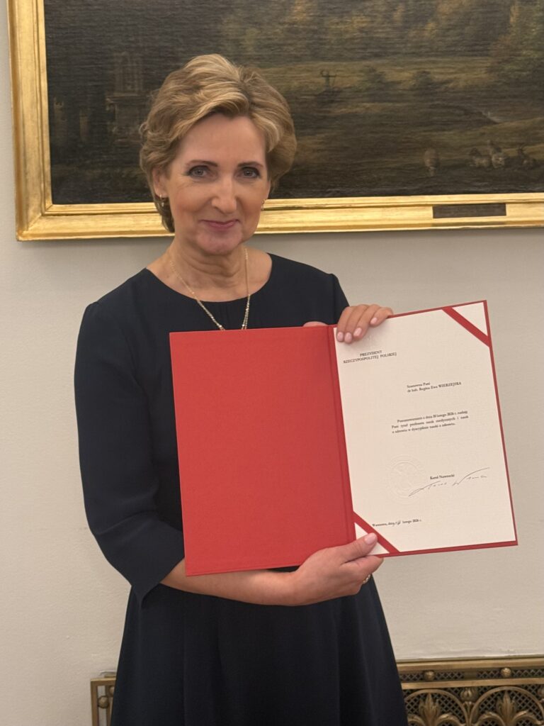 Profesor Wierzejska trzymająca otwarty dyplom tytułu profesora.